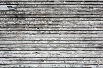 Weathered wooden lap siding with peeling paint