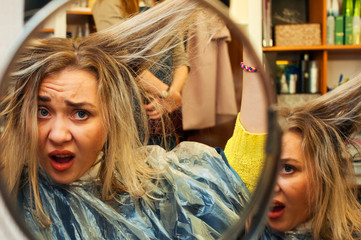 sad european woman at the hairdresser is unhappy with her hair. Hair problems, bad shampoo.