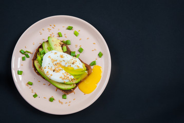 Toast with avocado poached egg and flax seeds. Top view. Copy space