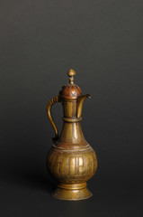 ancient oriental metal teapot on dark background. antique bronze tableware