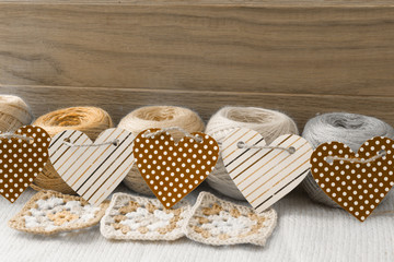 Colorful yarn for knitting, decorated with a garland of hearts. Image in sepia tones.