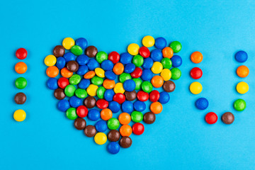 Glazed chocolate colored candies laid out in "I love you"