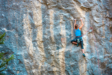 Fototapeta premium A woman climbs the rock.