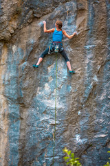 Fototapeta premium A woman climbs the rock.