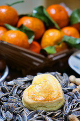 Heart shaped scone with a basket of oranges in the background