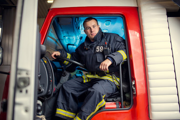 Photo of fireman man sitting in fire truck