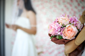 Obraz na płótnie Canvas Bride in dress holding wedding bouquet of flowers and greenery,Happy wedding concept.