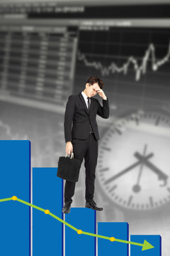 stressed businessman with falling down business chart background