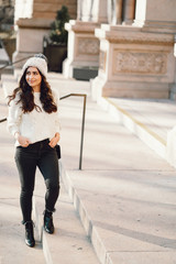 Cute brunette in a white sweater in a city