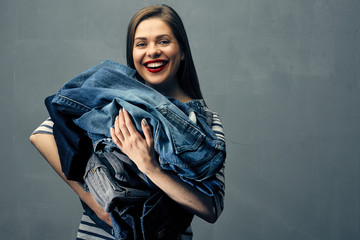 young woman holding blue denim clothes.