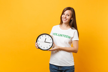 Portrait of pretty woman in white t-shirt with written inscription green title volunteer hold round...