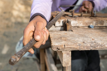 Worker bending steel with steel bending equipment by hand.