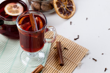 Mulled wine in glass with orange and spices .