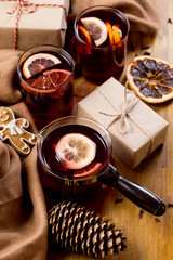 Mulled wine in glass mug with spices. Christmas hot drink on wooden table. Top view.