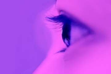 vertical eye closeup on purple neon light