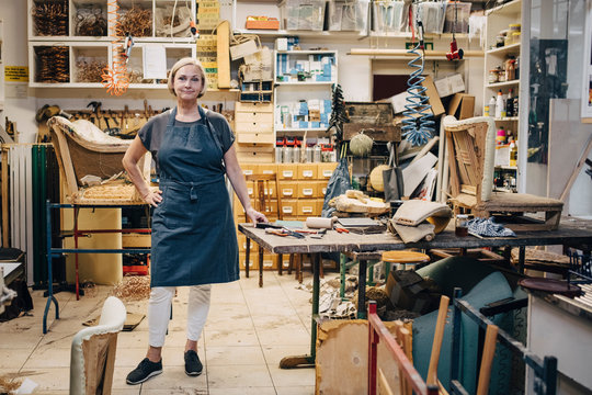 Portrait of female upholsterer standing in workshop