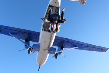 Fototapeta na wymiar Tandem skydiving. Girl-passenger is having fun in the sky.