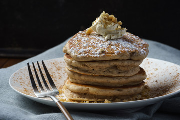 original pancakes with cinnamon and whipped butter topping on plate with fork