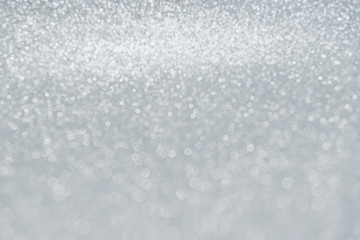 Delicate white glitter bokeh background. Glowing texture.