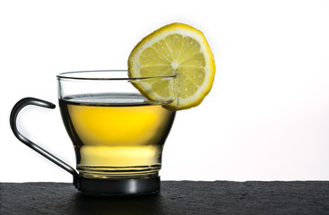 Lemon tea in a glass cup against a white background