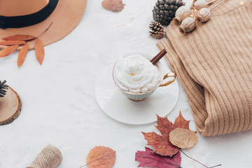 Fototapeta na wymiar Cozy Autumn and Winter composition. Hot coffee with warm sweater, autumn leaves, hat and fall accessories. Top view, flat lay