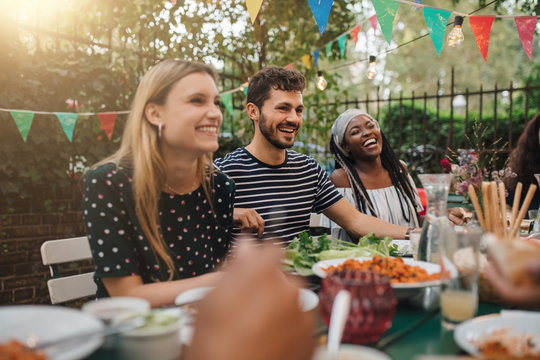 Smiling friends enjoying food during party in backyard