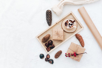 Flat lay christmas gift, hot cocoa and decoration on white cozy background