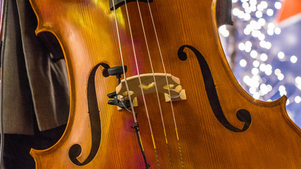 Close up of a cello, christmas lights and glitters are in the background. © Daniel Avram