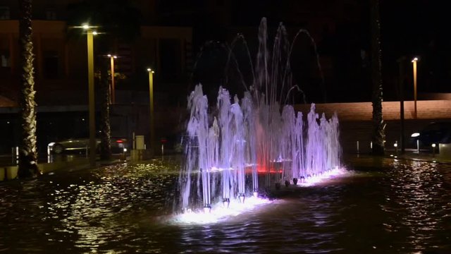 Illuminated and colorful fountain at night. Multi-coloured water jets in fountain pool. City cente Durres, Albania
