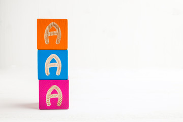Word AAA made from wooden multicolored cubes