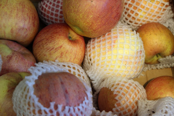Close up of Ripe red apples on the counter market stall. Background texture of apple. Chaotic backdrop, view top. 