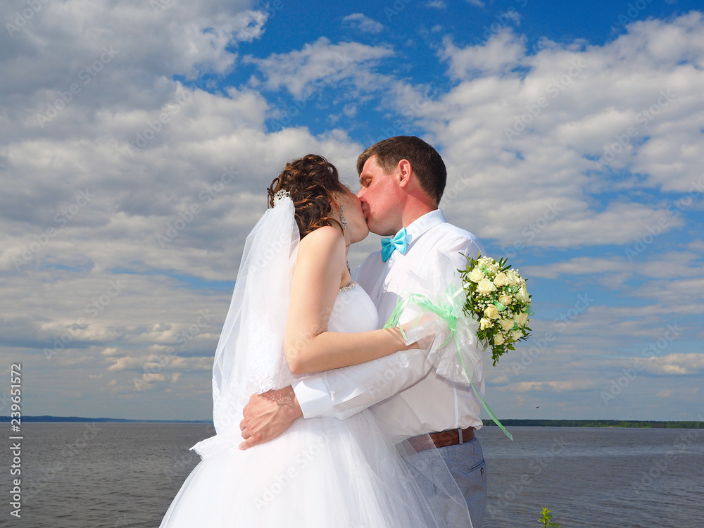 Wall mural Wedding, the couple kissing. Summer on the beach