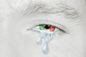 Crying eye with the flag of Italy in iris on black and white face. Concept of sadness for Italian pain about financial crisis, austerity, financial plan and patriotic metaphor.