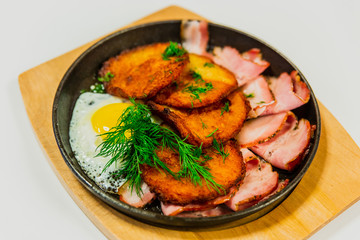 Potato pancakes with fried egg, bacon and dill