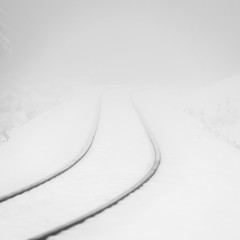 Railway track into snowy mist