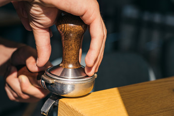 The perfect coffee that suits to your taste. Barista press coffee with tamper in portafilter. Brewing coffee equipment. Barista brew espresso drink in cafe. Coffee making in coffeehouse