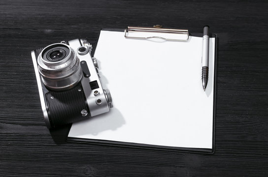 Shot list mockup. Photo session contract template. Vintage film photo camera and blank paper page on black wooden table background. Top view photo. - Powered by Adobe