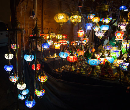 Various colorful round shaped retro glass lamps in darkness, in the market, as vintage color effect