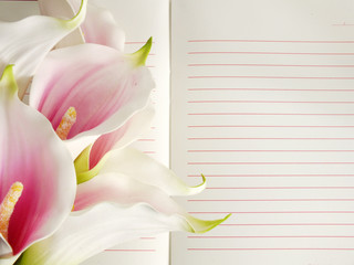 open notebook and beautiful calla artificial pink flowers bouquet