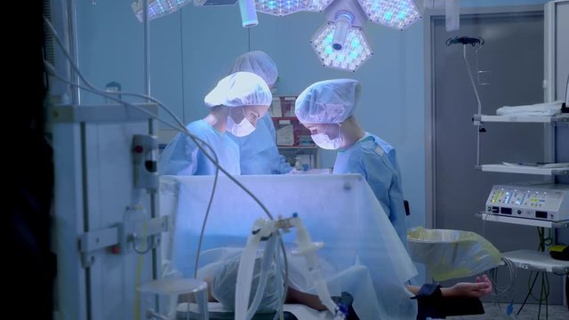 Medical Team Performing Surgical Operation in Bright Modern Operating Room.
