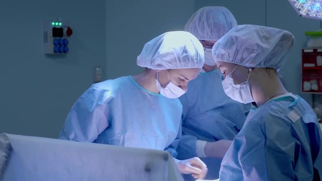 Medical Team Performing Surgical Operation in Bright Modern Operating Room.