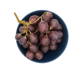 Bunch of purple grapes in a plate isolated on white background