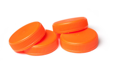 closeup of orange plastic plugs for recycling on white background
