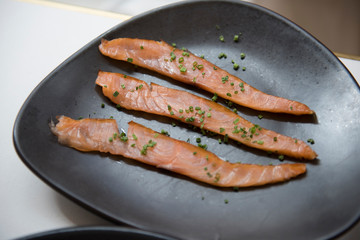 Image of very delicious and tasty smoked salmon with chives seen being served at a restaurant. The food seems to be very delicious and looks very fresh.