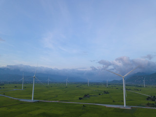 Fototapeta na wymiar Wind turbine farm or windmill on a summer day. High-quality stock photo image wind turbine or windmill in a green field - Energy Production with clean and Renewable Energy. Phan Rang, Vietnam