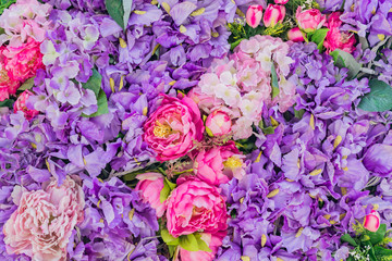 Obraz premium Floral background. Decorative wall made of Artificial blooming peonies of pink and purple colors