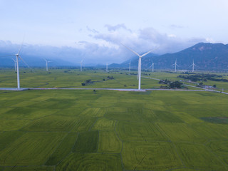 Fototapeta na wymiar Wind turbine farm or windmill on blue sky. Turbine green energy electricity or wind turbine in a green field - Energy Production with clean and Renewable Energy. Phan Rang, Vietnam