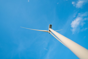 View up, bottom view of wind turbine, windmill isolated on blue sky background. Royalty...