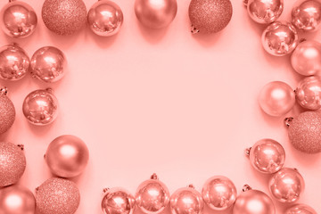 Christmas silver baubles as frame on living coral background. Top view with space for text.