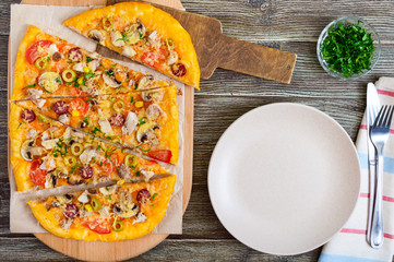 Tasty pizza with mushrooms, chicken, pepperoni, olives, corn cut into pieces on a wooden tray. The top view